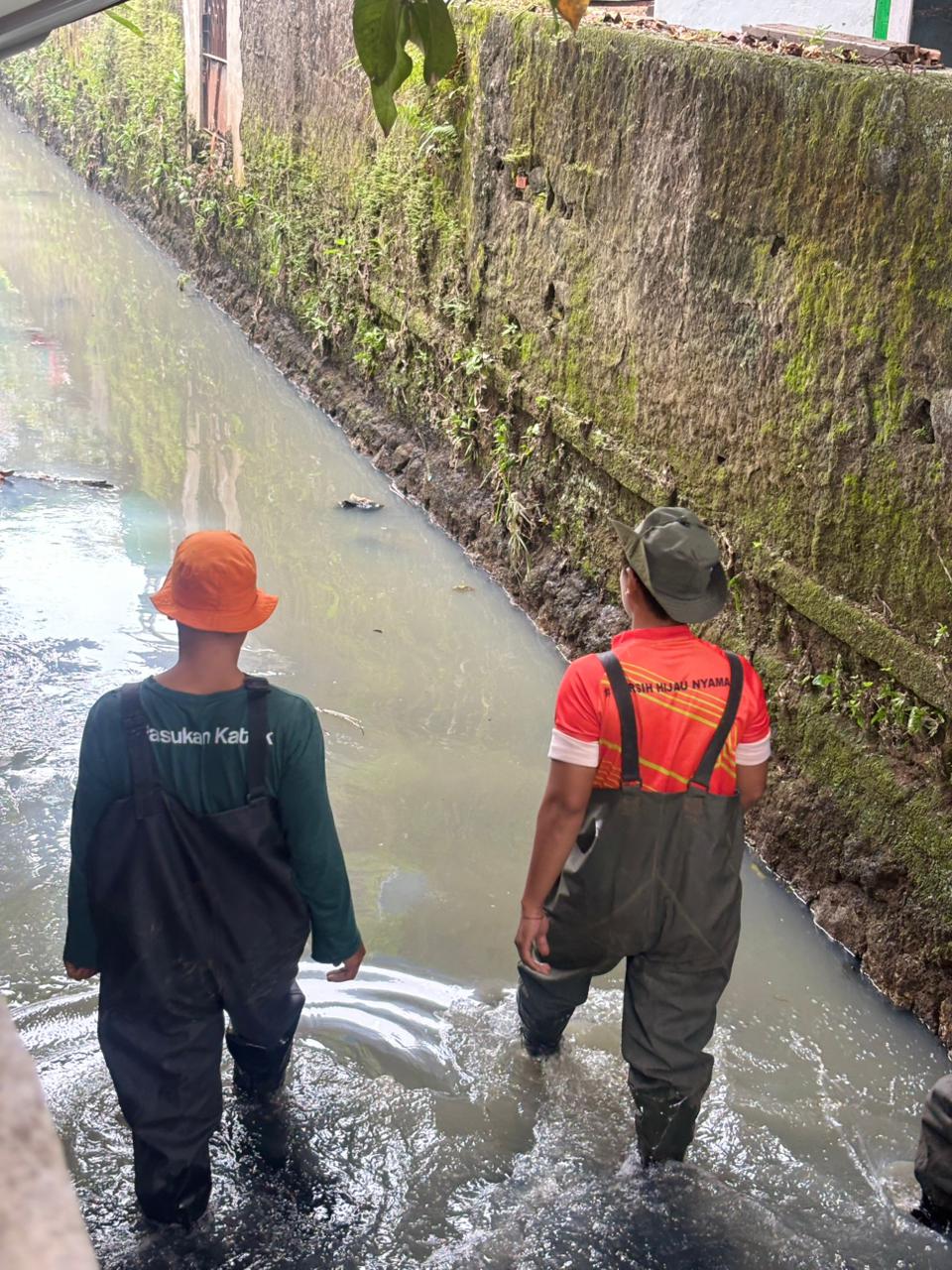 Kota Bekasi - Petugas dari Dinas Lingkungan Hidup saat menyusuri saluran dan badan air bau menyengat di Kali Jakamulya. Foto: Ist/Gobekasi.id.