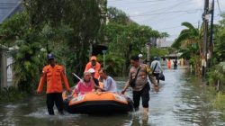 Polsek Medan Satria Evakuasi Warga Sakit di Tengah Genangan Air di Pejuang