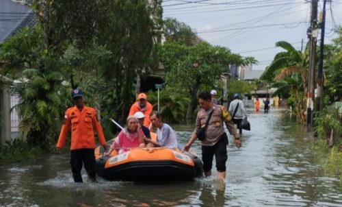 Kota Bekasi - Petugas Polsek Medan Satria mengevakuasi seorang warga yang sakit di wilayah Kelurahan Pejuang, Kecamatan Medan Satria, Kota Bekasi, Minggu (18/1/2026). Foto: Ist/Gobekasi.id.