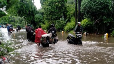 Kota Bekasi - Pengemudi mendorong sepeda motor dari genangan banjir di Kota Bekasi, Minggu (18/1/2026). Foto: Ist/Gobekasi.id.