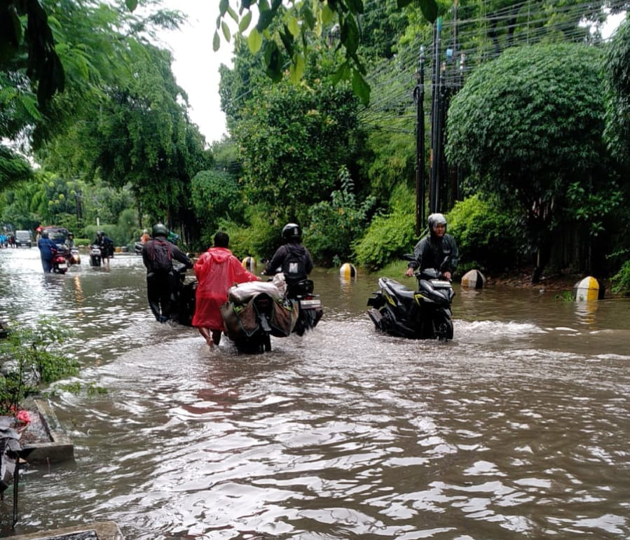 Kota Bekasi - Pengemudi mendorong sepeda motor dari genangan banjir di Kota Bekasi, Minggu (18/1/2026). Foto: Ist/Gobekasi.id.