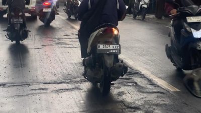 Kota Bekasi - Hujan deras dalam sepekan terakhir hingga banjir membuat banyak kontur jalan berlubang dan aspal yang mengelupas di Kota Bekasi. Foto: Gobekasi.id.