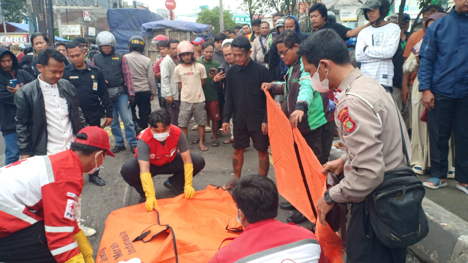 Kabupaten Bekasi - Petugas mengevakuasi jenazah pemotor berinisial SA (37) yang tewas tertabrak truk saat menghindari lubang di depan Kopi Kenangan, Desa Karang Baru, Kecamatan Cikarang Utara, Kabupaten Bekasi, Selasa (27/1/2026) sekitar pukul 11.20 WIB. Foto: Ist/Gobekasi.id.