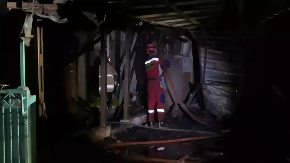 Kota Bekasi - Petugas Disdamkarmat Kota Bekasi saat melakuka proses pendinginan rumah warga yang terbakar hebat warga di Jalan Raya Perjuangan, Kelurahan Harapan Baru, Kecamatan Bekasi Utara., Selasa (17//2026) dini hari. Foto: Ist