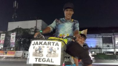 Kabupaten Bekasi - Waskum, pria yang memilih mudik dengan mengayuh sepeda dari Jakarta menuju Tegal, Jawa Tengah, sambil membawa anaknya saat melintas di Kawasan Tambun, Kabupaten Bekasi. Foto: Septian/Gobekasi.id.