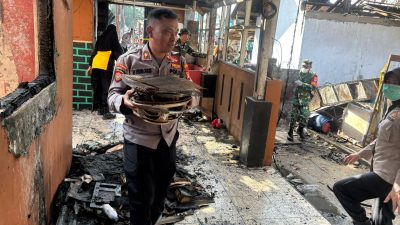 Kota Bekasi - Petugas Polres Metro Bekasi Kota saat membangtu pembersihan bangunan rumah warga pasca ledakan SPBE Cimuning