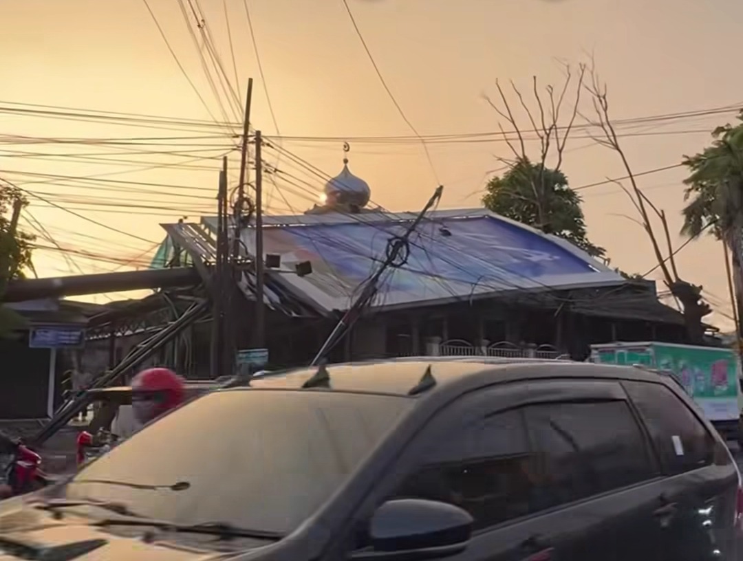 Kota Bekasi - Reklame ambruk menimpa bangunan warga di Jalan Narogong usai hujan dan angin kencang yang melanda Kota Bekasi, Minggu (12/4/2026) sore. Foto: Gobekasi.id.