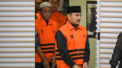 Bekasi - Bupati Bekasi Ade Kuswara Kunang bersama ayahnya HM Kunang (kiri) dan pihak swasta Sarjan (kedua kiri) dihadirkan saat konferensi pers operasi tangkap tangan (OTT) di Gedung Merah Putih KPK, Jakarta, Sabtu (20/12/2025). Foto: Antara
