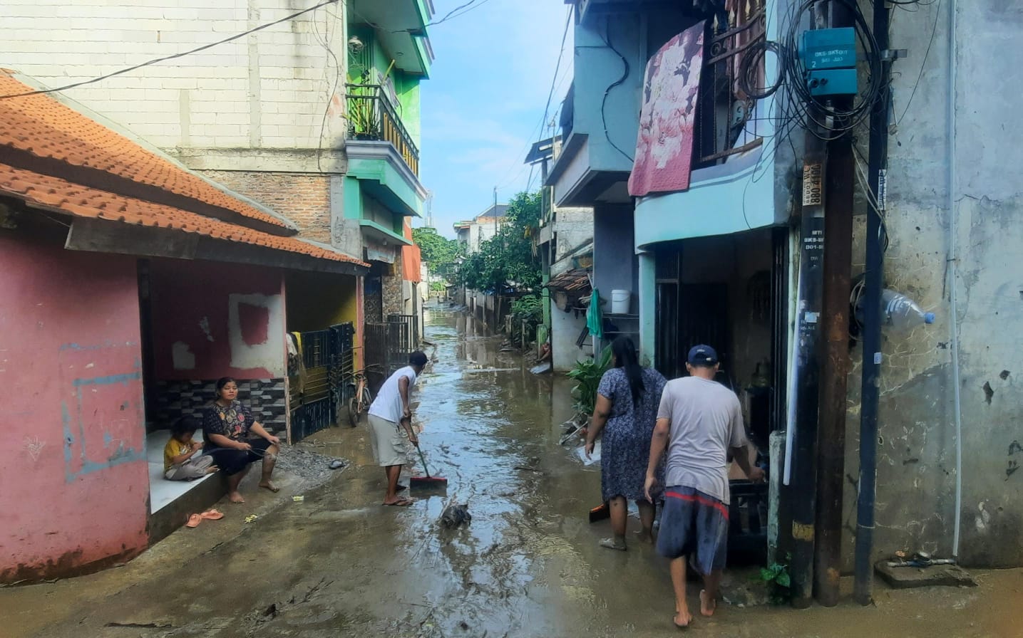 Bekasi - Warga di Gang Mawar, Bekasi Timur, membersihkan lumpur sisa banjir akibat luapan Kali Bekasi, Senin (5/5/2026). Foto: Septian/Gobekasi.id.