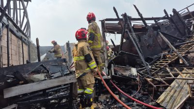 Bekasi - Petugas Disdamkarmat Kota Bekasi melalukan pemadaman tiga bangunan di Jalan Irigasi, Kelurahan Medan Satria, Kecamatan Medan Satria, Kota Bekasi, pada Jumat (15/5/2026). Foto: Septian/Gobekasi.id.