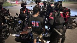 Bekasi - Personel Brimob Polda Metro Jaya saat mengamankan pemuda yang diduga menjadi joki balap liar di kawasan MM2100. Foto: Ist
