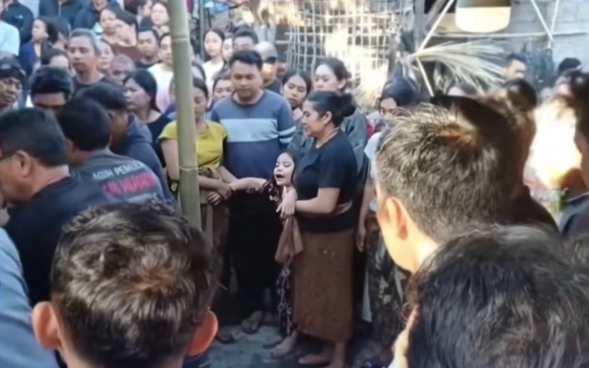 Bekasi - Seorang wanita beliau histeris melihat jasad ayahnya yang kaku di bopong oleh warga karena dituduh mencuri ayam aduan di Baturiti, Tabanan, Bali. Foto: Istimewa