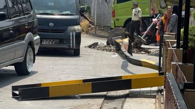 Bekasi - Truk Fuso menabrak portal di Jalan Caringin, Bekasi, Senin (21/9/2026). Tiang roboh dan menimpa pengendara Honda Vario hingga terluka. Foto: Ist/Gobekasi.id.