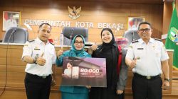 Bekasi - Ketua TP PKK Kota Bekasi Wiwiek Hargono Tri Adhianto membagikan masker secara simbolis dalam pertemuan rutin TP PKK Kota Bekasi di Gedung Nonon Sonthanie, Rabu (9/9/2026). Foto: Ist/Gobekasi.id.