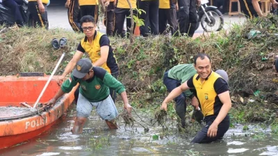 Bekasi - Kapolres Metro Bekasi Kota Kombes Putu Kholis Aryana turun langsung bersihkan Kali Baru, Jumat (23/10/2026). Dorong mitigasi banjir via gerakan Green Policing. Foto: Ist/Gobekasi.id.