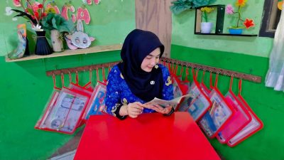 Bekasi - Guru SDN Duren Jaya 4, Widya, saat membaca Novel Ratu Kali Bhagasasi Karya Wiwiek Hargono. Foto: Gobekasi.id.