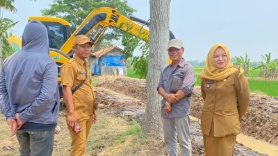 Bekasi - Penjabat (Pj) Kepala Desa Sukakarya, Siti Nurasiah saat meninjau pekerjaan fisik normalisasi Saluran Sekunder (SS) Gempol Payung di wilayah Desa Sukakarya, Kecamatan Sukakarya, Kabupaten Bekasi. Foto: Ist/Gobekasi.id.
